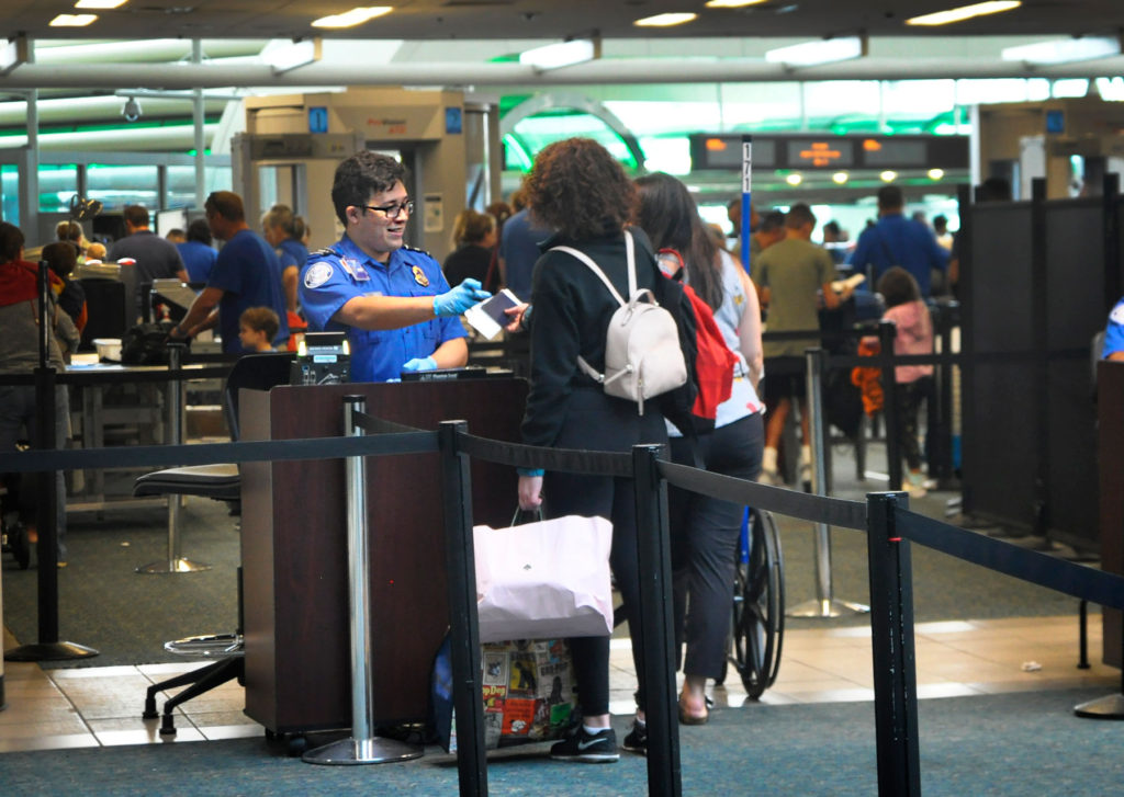 TSA officers talk with passengers at Orlando International Airport. Photo Isaac Babcock